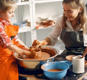 Girl make a vase. Pottery theme. On a pottery's machine. Little child on a master class.